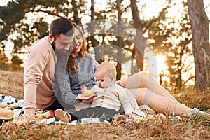 Haves picnic. Happy family of mother, family and little baby rests outdoors. Beautiful sunny autumn nature