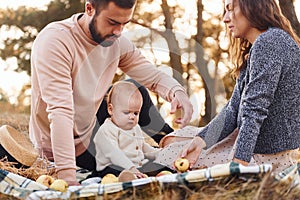 Haves picnic. Happy family of mother, family and little baby rests outdoors. Beautiful sunny autumn nature