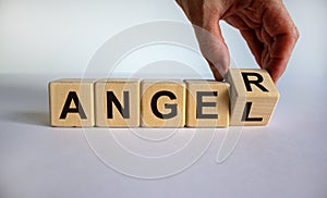 Having anger or being an angel. Hand turns a cube and changes the word `anger` to `angel`. Beautiful white background. Busines photo
