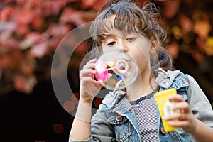 Having bubble fun. a little girl blowing bubbles outdoors.