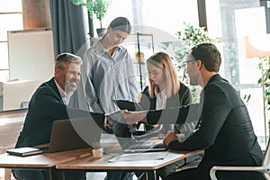 Having conversation, talking about plan. Group of business people are working in the modern office