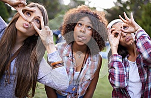 Having a crazy day with some friends. Cropped portrait of a group of girl friends pulling funny faces while at the park.