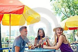 Having drinks with a few close friends. three young friends sitting at an outdoor cafe.