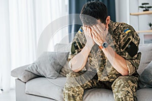 Having flashbacks. Post traumatic stress disorder. Soldier in uniform sitting indoors