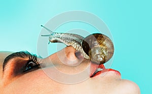 Having fun with adorable snail. Cosmetics and snail mucus. Girl fashionable makeup face and cute snail. Cosmetology