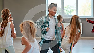 Having fun. Group of positive children learning a modern dance in the dance studio. Choreography concept