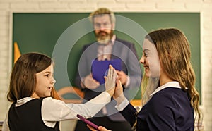 having fun. small girls children at school. back to school. Teacher and pupils working at desk together at the