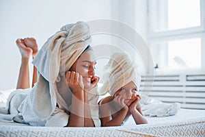 Having fun. Young mother with her daugher have beauty day indoors in white room