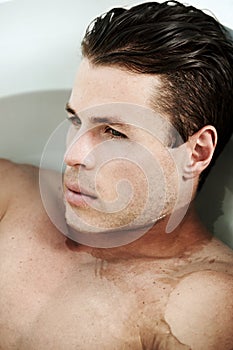 Having a moment of peace. a sexy man lying in the bath.