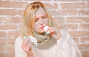 Having nasal stuffiness. Pretty girl with runny nose holding nasal drops. Sick woman injecting drops into nose. Cute