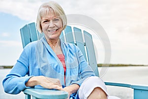 Having the rest of my life. Portrait of a happy senior woman relaxing on a chair outside.