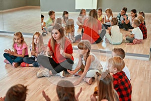 Having some fun after choreography class. Young female dance teacher with group of happy children clapping and playing