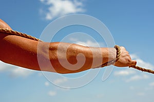 Having strength in his muscles. Male muscular hand pulling rope. Strong arm tugging rope. Test of muscular strength photo