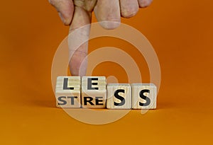 Having less stress or being stress-less. Male hand turns wooden cubes and changes the word `STRESS` to `LESS`. Beautiful orang