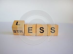 Having less stress or being stress-less. The word `STRESS` and `LESS` on wooden cubes. Beautiful white background, copy space