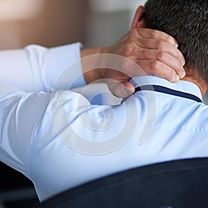 Having the worst day at work. a businessman suffering from neck pain.