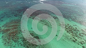 Hawaii, low angle view with drone camera moving forward, reef in clear green open water with camera closing in on breaking waves