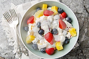 Hawaiian Berry Cheesecake Salad with strawberries, blueberries, pineapple, dressed with whipped cream cheese close-up in a bowl.