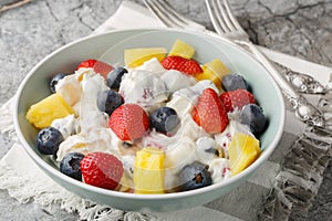 Hawaiian Berry Cheesecake Salad with strawberries, blueberries, pineapple, dressed with whipped cream cheese close-up in a bowl.