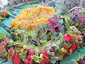 Hawaiian flower leis on display at an outdoor festival