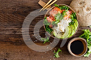 Hawaiian poke coconut bowl with grilled salmon fish, rice and avocado. Healthy food