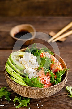 Hawaiian poke coconut bowl with grilled salmon fish, rice and avocado. Healthy food