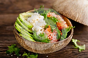 Hawaiian poke coconut bowl with grilled salmon fish, rice and avocado. Healthy food