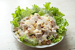 Hawaiian salad in the plate. Chopped ruddy chicken breasts with leaf salad, pieces of pineapple and crushed walnut.