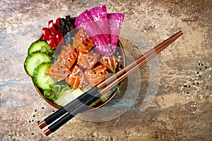 Hawaiian salmon poke bowl with seaweed, watermelon radish, cucumber, pineapple and sesame seeds. Copy space