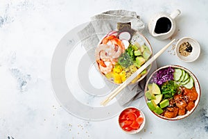 Hawaiian salmon and shrimp poke bowls with seaweed, avocado, mango, pickled ginger, sesame seeds.