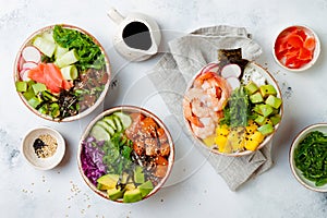 Hawaiian salmon, tuna and shrimp poke bowls with seaweed, avocado, mango, pickled ginger, sesame seeds.