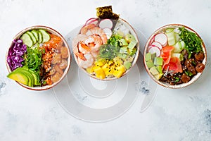 Hawaiian salmon, tuna and shrimp poke bowls with seaweed, avocado, mango, pickled ginger, sesame seeds.