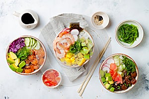 Hawaiian salmon, tuna and shrimp poke bowls with seaweed, avocado, mango, pickled ginger, sesame seeds.