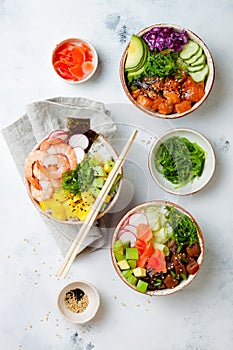 Hawaiian salmon, tuna and shrimp poke bowls with seaweed, avocado, mango, pickled ginger, sesame seeds.