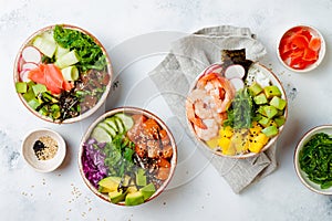 Hawaiian salmon, tuna and shrimp poke bowls with seaweed, avocado, mango, pickled ginger, sesame seeds.