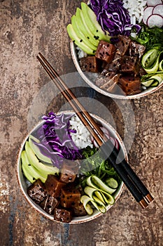 Hawaiian tuna poke bowl with seaweed, avocado, red cabbage slaw, radishes and black sesame seeds.