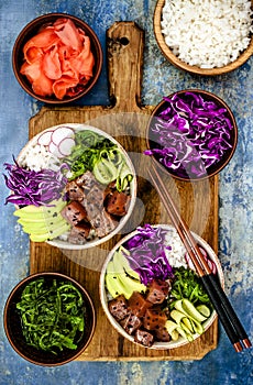 Hawaiian tuna poke bowl with seaweed, avocado, red cabbage slaw, radishes and black sesame seeds.