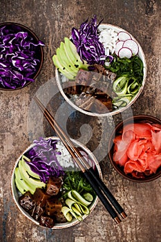 Hawaiian tuna poke bowl with seaweed, avocado, red cabbage slaw, radishes and black sesame seeds.