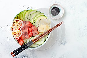 Hawaiian watermelon poke bowl with avocado, cucumber, mung bean sprouts and pickled ginger. Top view, overhead