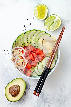 Hawaiian watermelon poke bowl with avocado, cucumber, mung bean sprouts and pickled ginger. Top view, overhead