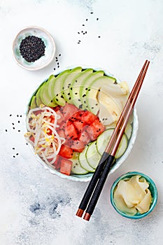 Hawaiian watermelon poke bowl with avocado, cucumber, mung bean sprouts and pickled ginger. Top view, overhead