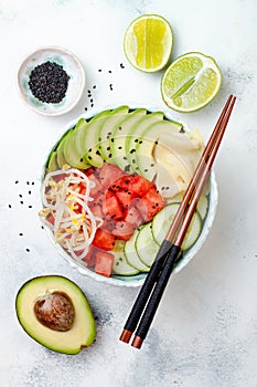 Hawaiian watermelon poke bowl with avocado, cucumber, mung bean sprouts and pickled ginger. Top view, overhead