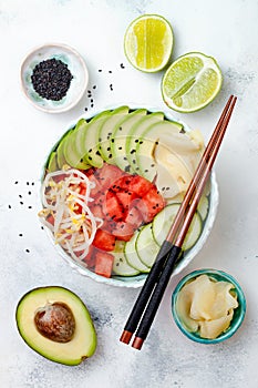 Hawaiian watermelon poke bowl with avocado, cucumber, mung bean sprouts and pickled ginger. Top view, overhead