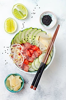 Hawaiian watermelon poke bowl with avocado, cucumber, mung bean sprouts and pickled ginger. Top view, overhead