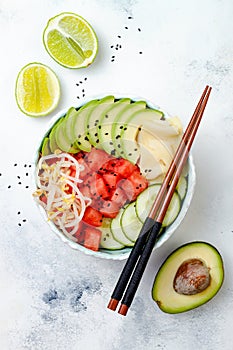 Hawaiian watermelon poke bowl with avocado, cucumber, mung bean sprouts and pickled ginger. Top view, overhead