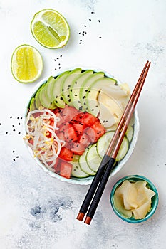 Hawaiian watermelon poke bowl with avocado, cucumber, mung bean sprouts and pickled ginger. Top view, overhead