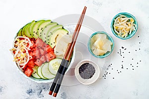Hawaiian watermelon poke bowl with avocado, cucumber, mung bean sprouts and pickled ginger. Top view, overhead