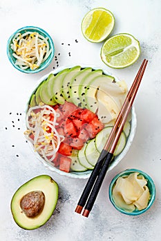 Hawaiian watermelon poke bowl with avocado, cucumber, mung bean sprouts and pickled ginger. Top view, overhead