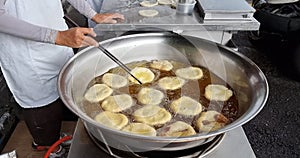 Hawker deep frying the Ham Chim Peng in wok with hot oil, a popular Chinese street food in Malaysia