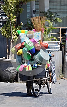 Hawker of plastic goods wheeling pushbike Canggu bali photo